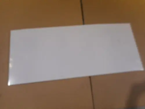 Weißes, glattes Plattenelement auf einer Unterlage. Es könnte sich um eine Abdeckhaube von Remeha handeln. Die Oberfläche ist ohne erkennbare Details oder Muster.
